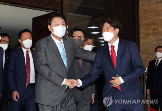 윤석열 대통령이 16일 오전 서울 여의도 국회에서 코로나19로 인해 피해를 본 소상공인·자영업자의 보상을 위한 추가경정예산안의 신속한 처리를 요청하는 시정연설을 마친 뒤 국회를 나서며 국민의힘 이준석 대표와 악수하고 있다. <연합뉴스>